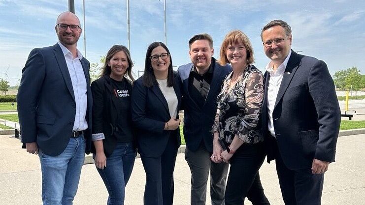 A group of people standing on the sidewalk
