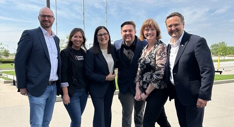 A group of people standing on the sidewalk
