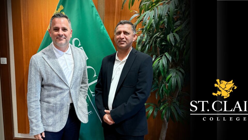 two men in front of flag in board room